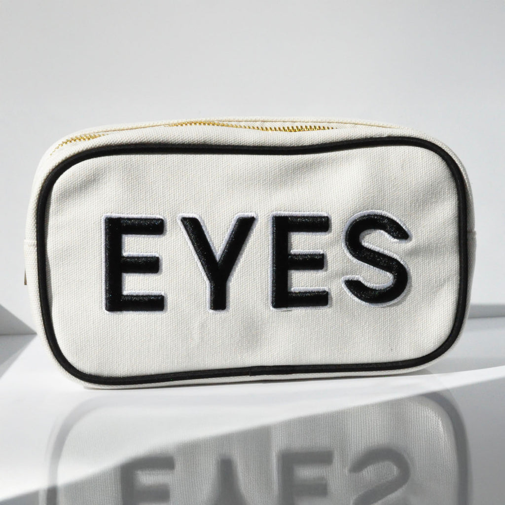 We Love Eyes canvas cosmetic bag in Mod Moda in White canvas with 'EYES' text in black embroidered letters and black piping 